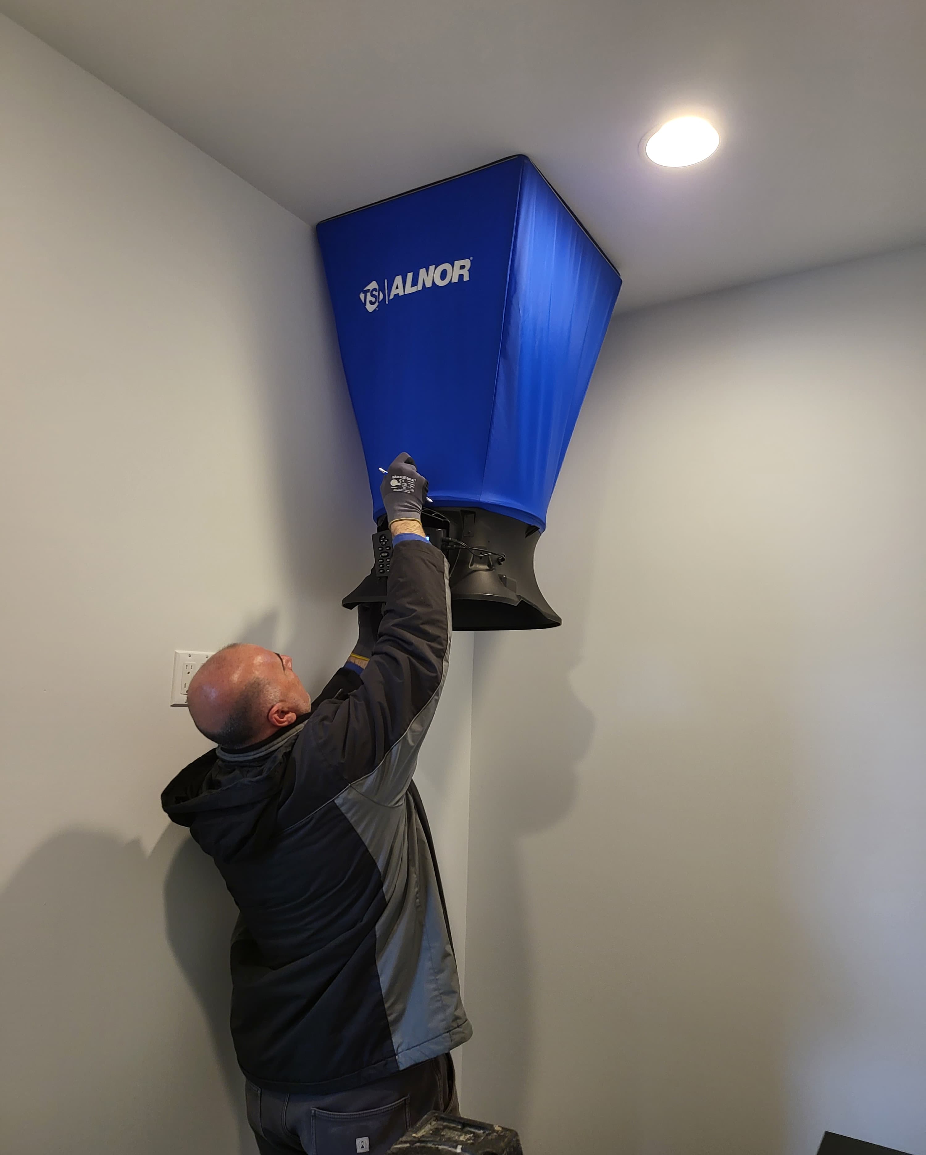 Technician using an air hood to verify airflow and balancing performance